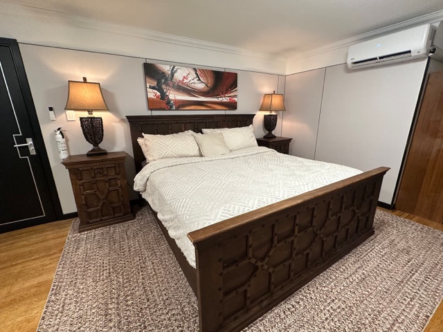 King bed with carved wood frame and bedside lamps
