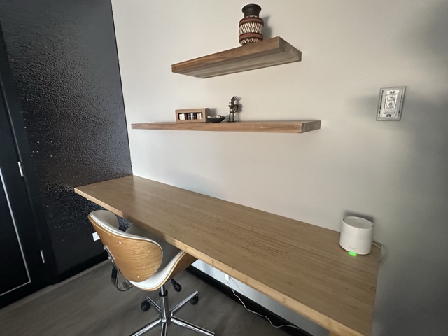 Desk with an office chair and floating shelves in the second bedroom