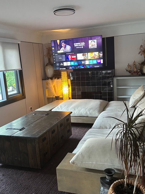 Living room with the white sectional sofa, a wooden chest coffee table and a potted palm